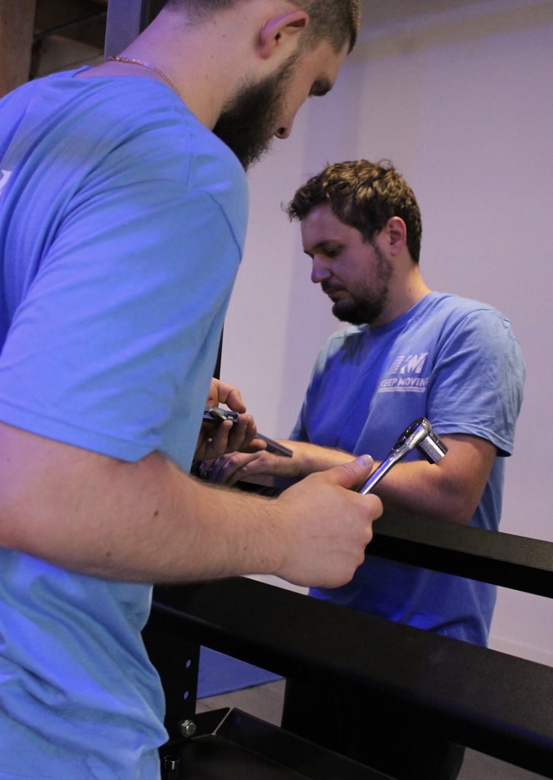 Keep Moving movers in blue shirts assembling furniture during a Toronto condo move