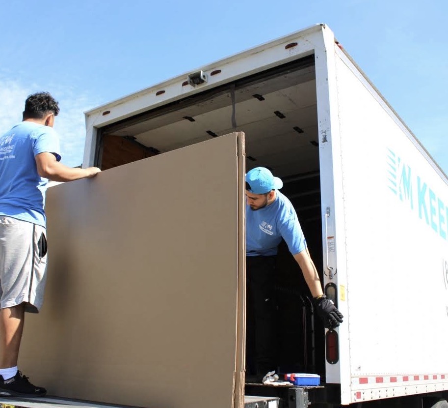 Stacked moving boxes beside a Keep Moving truck