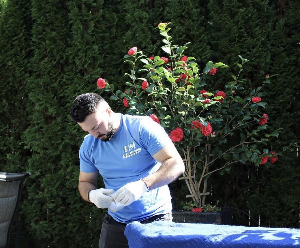 Keep Moving mover in a blue shirt holding tape during a Toronto move