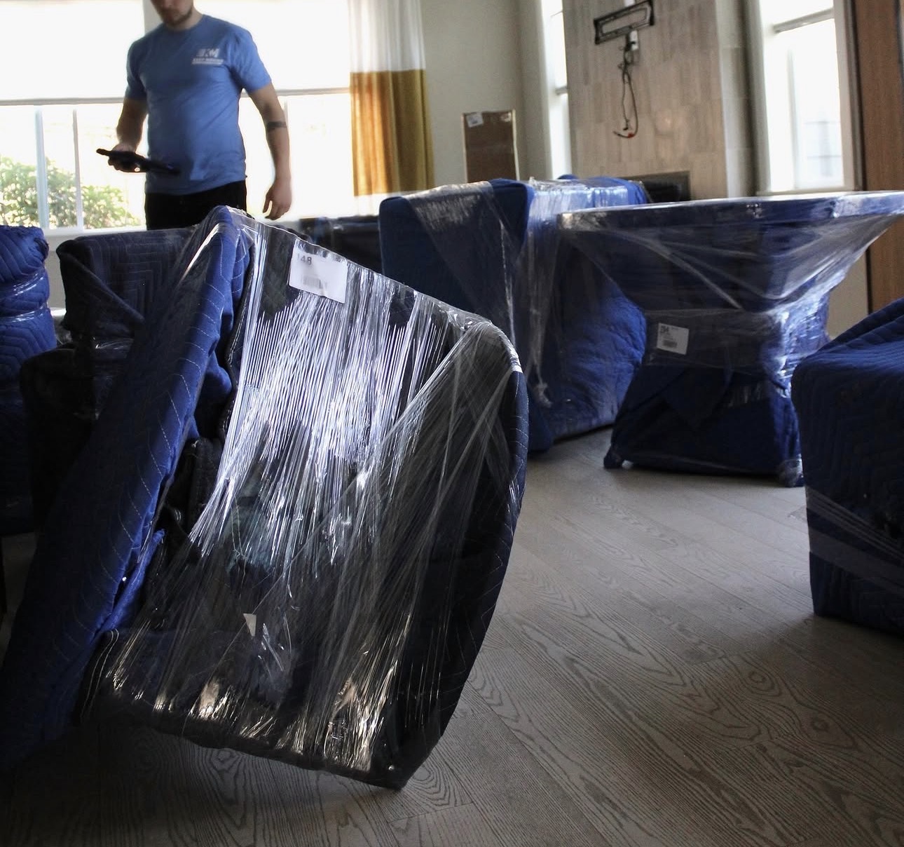Keep Moving movers wrap furniture in moving blankets and plastic wrap during a cross-border household move