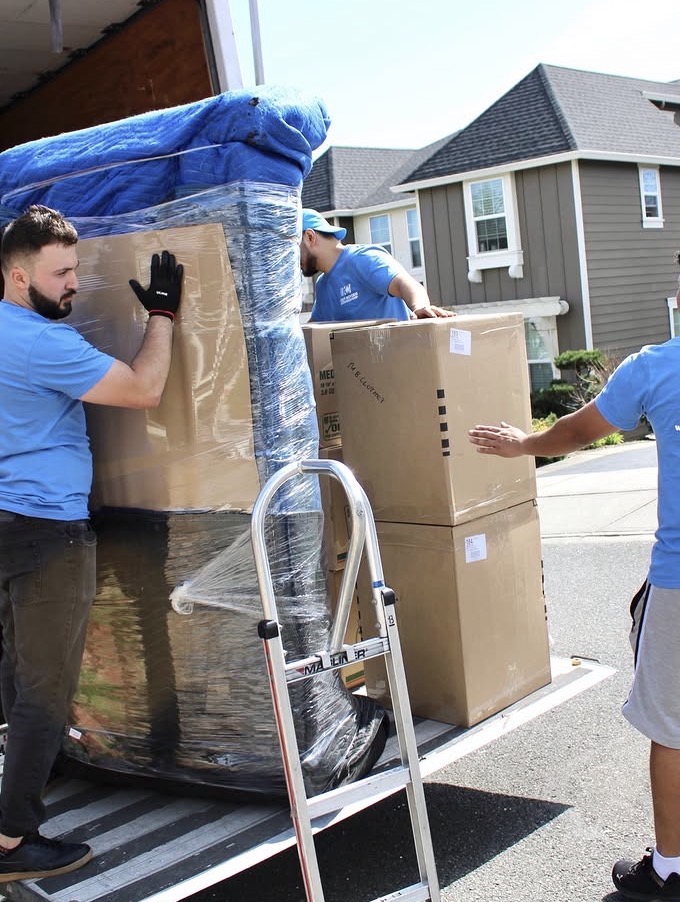 Keep Moving crew loading boxes and wrapped furniture on a truck liftgate during a Toronto condo move