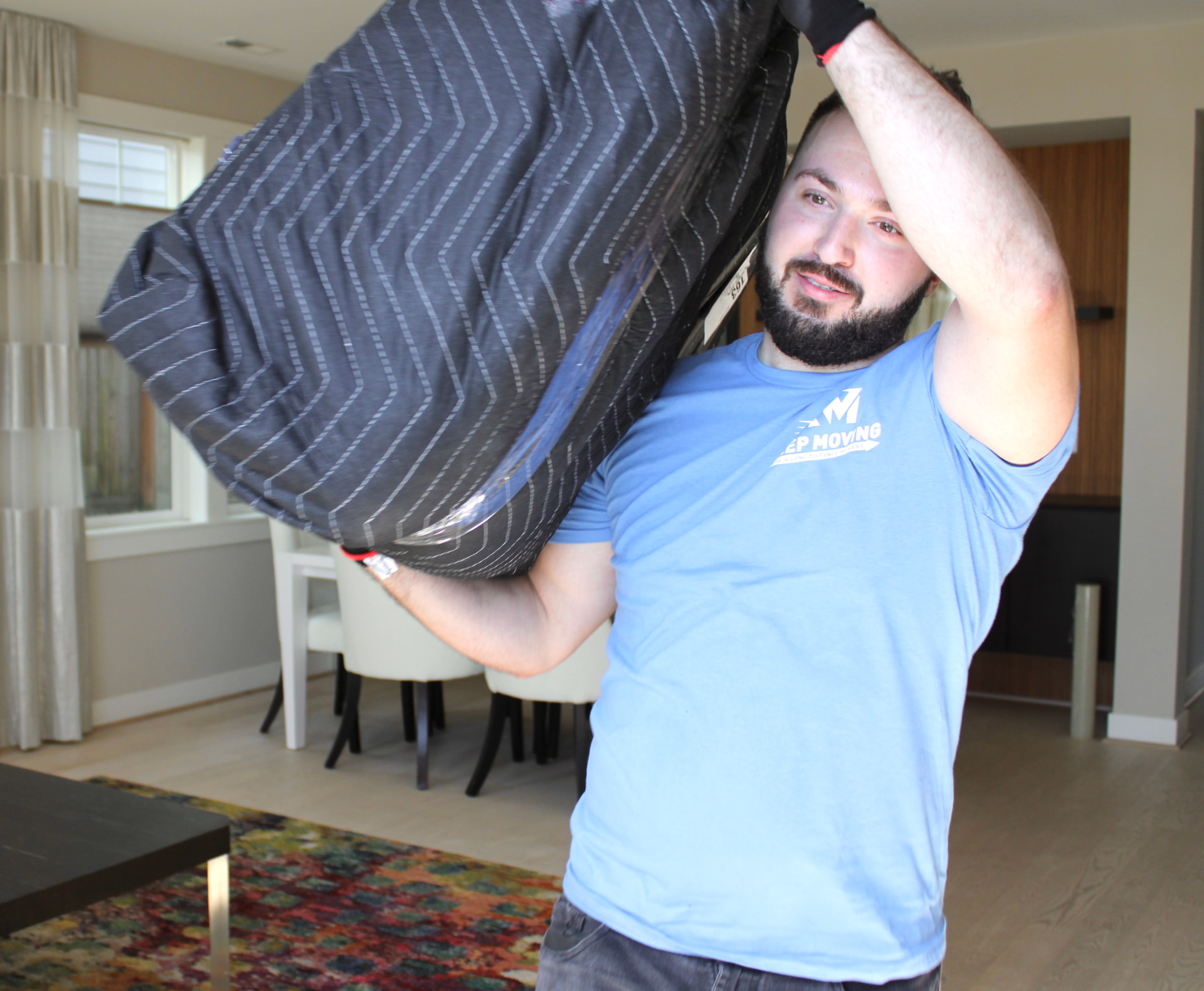 Toronto residential movers carrying a wrapped item inside a home